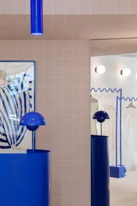Industrial storefront with blue message board, glass case, and metal display stand.