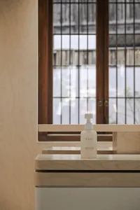 A clean, modern bathroom with a wooden vanity and window.
