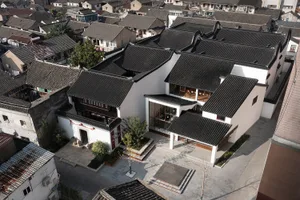 俯瞰傳統中式房屋，屋頂覆蓋陶土瓦片，白牆搭配木樑結構。
