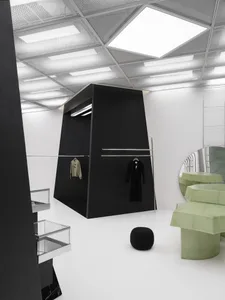 A modern clothing store with black and white interiors, featuring minimalist design and glass elements.