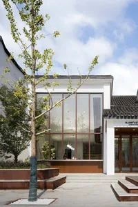 Modern building with large glass windows and traditional roof tiles