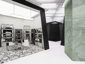 A modern interior design featuring black and white marble and metallic accents.