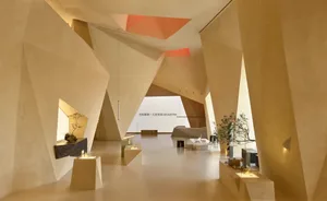 Modern interior space featuring geometric concrete walls and a hanging light fixture