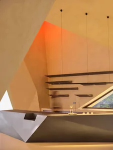A modern interior design space featuring a concrete bar with geometric shelves and metal accents.