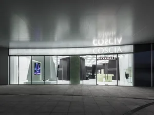 Modern storefront with large glass windows illuminated by neon lighting.