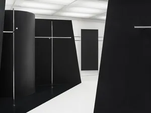 An abstract minimalist black and white interior space with geometric shapes and metallic accents.