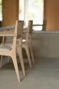 Modern, minimalist wooden chairs with a sleek, curved design in an interior setting.