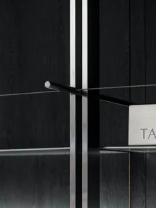 Close-up of modern metal furniture with glass shelves.