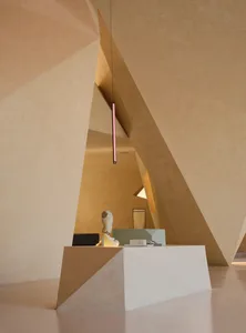 A modern interior design featuring a geometric concrete backdrop wall, a reception desk with a minimalist desk lamp and a scu