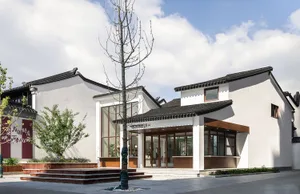A modern retail storefront with a white-painted exterior, black roofing, glass windows, and wooden columns.