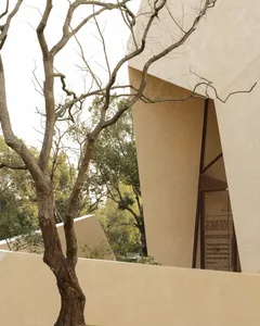 A modern building with a white stone exterior and a large arched doorway.
