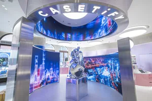 A futuristic retail storefront with metallic features and a digital display interior