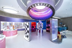 A colorful retail shop with pastel walls, metallic decor, and neon lights.