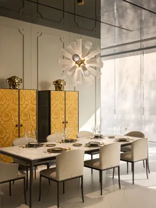 Modern dining room with a long table, chairs, and chandelier.