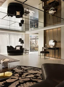 A modern living room featuring a round black sofa, a patterned rug, and a marble floor.