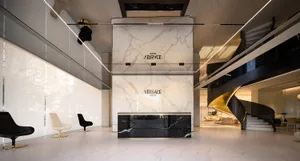 A modern retail storefront featuring glass, marble, and concrete materials, with a company logo displayed.