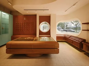 Modern retail shop featuring a large, wooden display table with starfish inside a retail environment.
