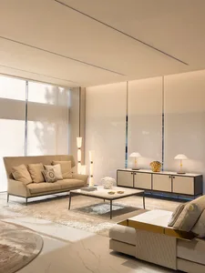 A modern living room featuring beige fabric couches, a marble coffee table, and a laminate flooring with a rug.