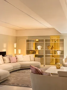 A modern living room featuring elegant fabrics, marble accent pieces, and metallic accents.