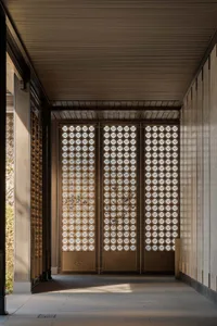 An entrance with a minimalist design featuring metal patterns and a wooden floor.
