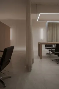 Minimalist interior design of a hair salon featuring wooden furniture and a sleek, modern aesthetic.