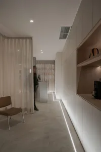 A minimalist living room with white walls and wood furniture, emphasizing the simplicity and elegance of the design.
