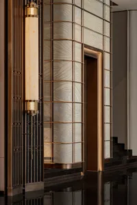 A modern hotel entryway with metallic frame wallpaper and black marble flooring