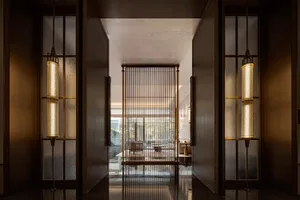 A modern hotel lobby featuring large glass panels and a clean, contemporary design.
