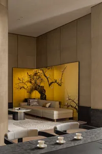A modern luxury lounge featuring gold leaf paneling with intricate designs on the walls and a comfortable seating arrangement