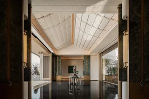 A modern lobby interior featuring marble flooring and walls.