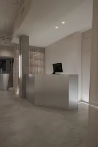 A sleek, modern office reception space featuring a concrete floor and minimalist design.
