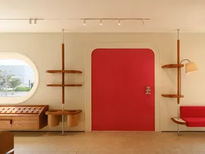 A modern retail interior featuring a vibrant red door and minimalist design elements.