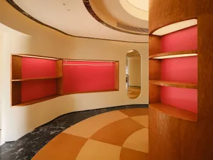 A modern retail storefront featuring wooden shelves with red backgrounds.