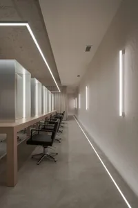 Modern salon interior with concrete walls and split-level design.