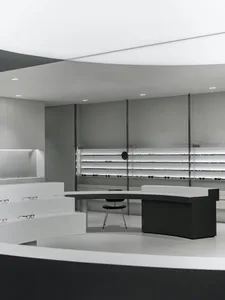 A modern retail storefront with minimalist design featuring black and white color palette, concrete and glass materials, and