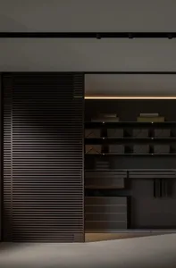 A modern dark wood closet system with sliding doors and integrated lighting.