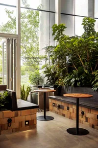 A modern coffee shop featuring industrial design elements with brick walls, wooden accents, and metal tables.