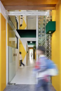 A modern corridor with glass walls and colorful geometric patterns.