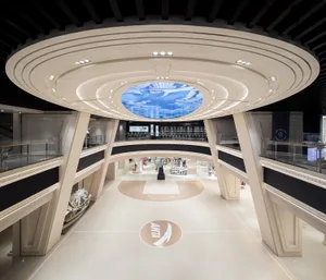 A modern shopping center interior featuring a sleek, concrete design with geometric elements and a central basketball court.