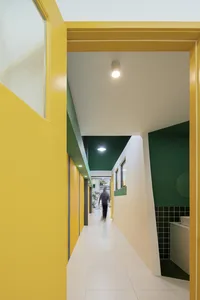 A brightly colored corridor with yellow walls and green accents.