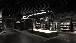 A minimalist retail space with a black metallic interior design and abstract lighting installation.
