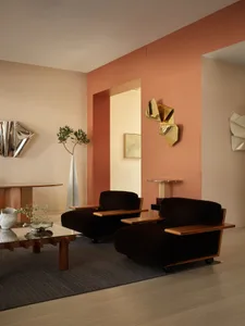 Modern living room featuring two dark brown velvet armchairs with wooden armrests and legs, placed on a dark gray rug over li