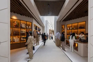 Modern retail shop featuring a concrete floor and wooden panels with illuminated wooden cabinets.