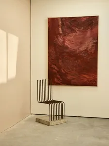 Modern art installation featuring a metal frame and a red abstract painting.
