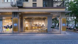 Modern coffee shop exterior made of concrete with a blurred background.