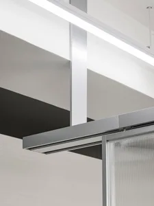 A modern office interior featuring glass panels and concrete structural elements.