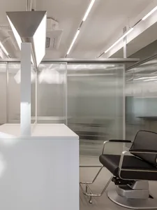 Contemporary office space featuring a sleek, modern design with glass walls and white surfaces.