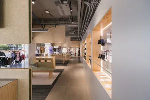 A modern retail store interior featuring wooden shelves and environmental displays.