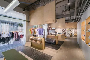 A modern retail storefront with a minimalist design, featuring neutral-toned materials and a spacious open floor plan.