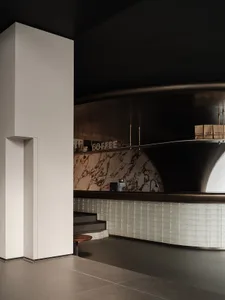 Modern minimalist coffee shop bar counter with white marble countertops and sleek, curved design.